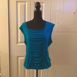 Woman sleeves less teal blouse with pleated front